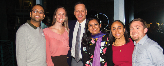 Brandeis president Ron Liebowitz flanked by five smiling men and women.